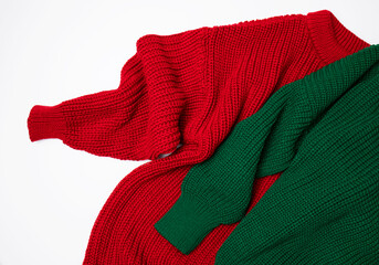 Red and green knitted sweater on white background top view. Texture of woolen cotton winter autumn...
