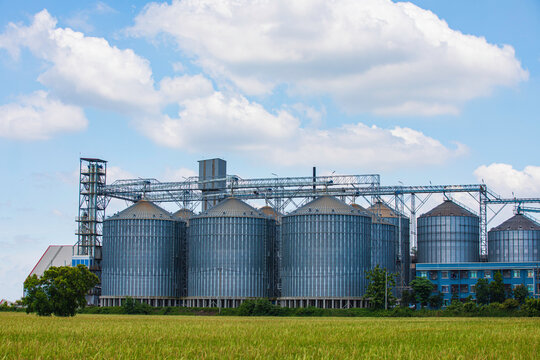 Plant for the drying and storage stainless silo grain. Rice plant in the middle of fields.