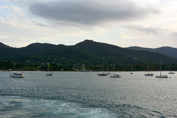 Strolling sailing yachts are moored near the seashore. A picturesque sea voyage