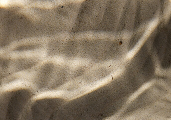 Under water texture light shadows on the beach sand. Close up