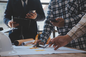 Obraz premium Construction and structure concept of Engineer or architect meeting for project working with partner and engineering tools on model building and blueprint in working site, contract for both companies.