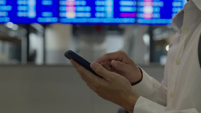 Business man using mobile phone to book plane ticket through online application, sitting on travel checking travel time on board at airport, travel, payment, due, booking, online, check in.