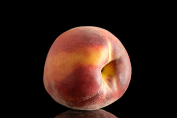 One ripe organic peach, macro, isolated on black background.