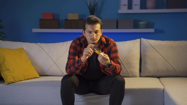 The man who looks at the pills in his hand and is going to commit suicide.