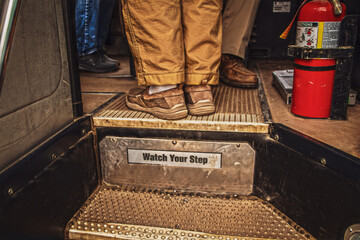Boarding a bus - men's feet at top of steps reading Watch Your Step and including bus drivers feet...
