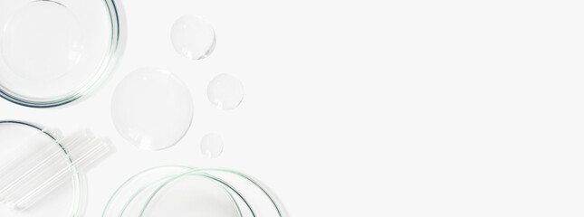 Petri dishes, flasks, test tubes. On a light background. Drops and smears of transparent gel. Laboratory. Banner. empty space for advertising