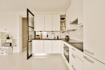 a modern kitchen with white cabinets and black counter tops on the island in this small space is very well organized