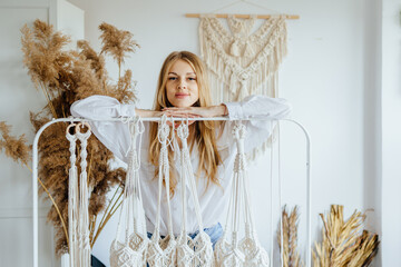 Creative macrame knitting weaving concept. Beautiful woman posing in studio over white background...