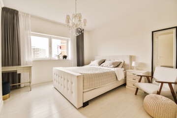 a bedroom with a bed, chair and mirror on the wall in front of the window looking out onto the street