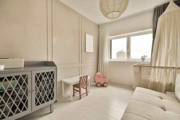 a baby's room with a cribt in the corner and a pink chair next to the cribt