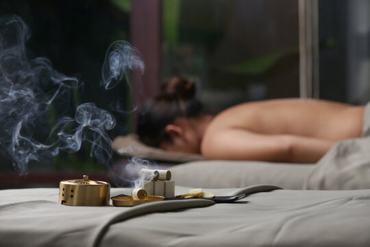 Moxibustion treatment - traditional Chinese medicine tools for acupuncture points heating therapy. Chinese herbal medicine. Moxibustion copper burner box with moxa herbal sticks in holistic spa.