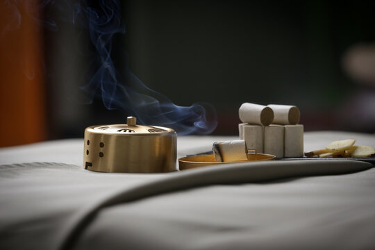 Moxibustion treatment - traditional Chinese medicine tools for acupuncture points heating therapy. Chinese herbal medicine. Moxibustion copper burner box with moxa herbal sticks in holistic spa.