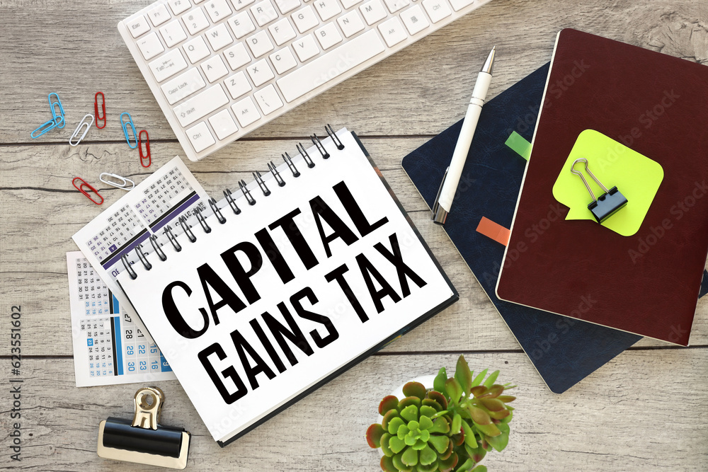 Poster open notepad with text near white keyboard..capital gains
