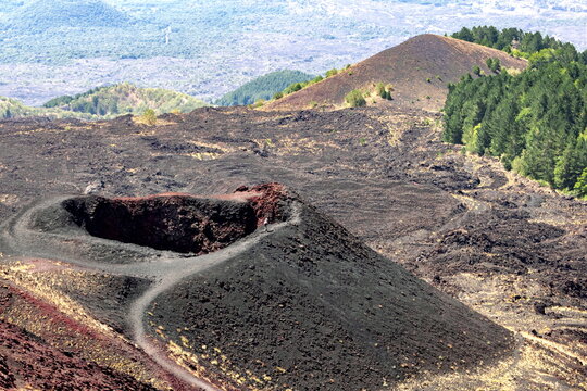Walking along the edge of a small crater on a tourist visit to Mount Etna