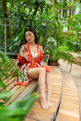 Woman resting in japanese garden. Wearing beach pareo