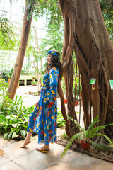 Woman posing in pareo bohemian summer dress near tropic trees