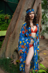 Woman posing in pareo bohemian summer dress near tropic trees