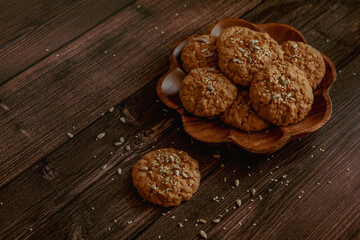 Oatmeal cookies on a dark wooden background with crumbs