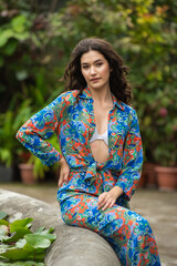 Naklejka premium Beautiful woman relaxing and posing on jungle resort near tropical trees