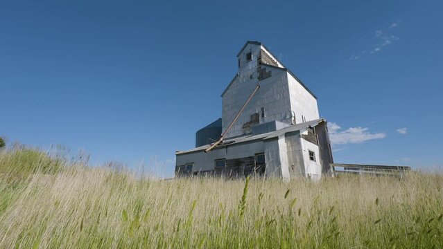 Old Wooden Grain Elevator Standing Tall Among Swaying Grass