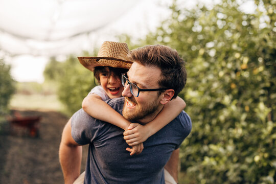 Closeup view of a cute boy on his fathers back in nature. - Powered by Adobe