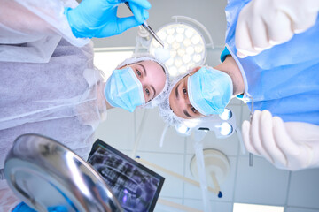 Surgeon and assistant in medical uniform are in operating room