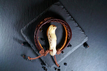 Walrus tusk amulet on a leather bracelet in the shape of a baby fur seal