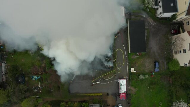 Top view of fire trucks and firefighters extinguishing a fire in a residential building.Emergency services at the scene, Fire in residential building in the city.Fire department, police and ambulance