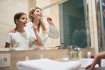Woman and daughter caring for teeth in the hotel