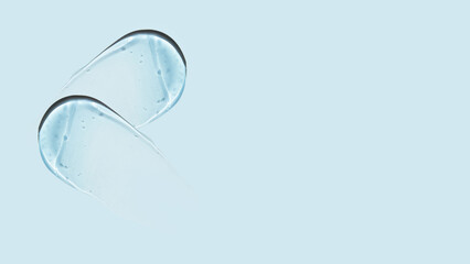 Drops and smears of a transparent gel or serum on a blue background. Banner with empty space for advertising.