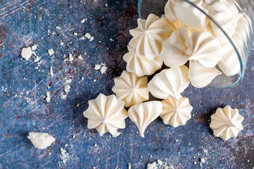 Small white meringues on a colored background - obrazy, fototapety, plakaty