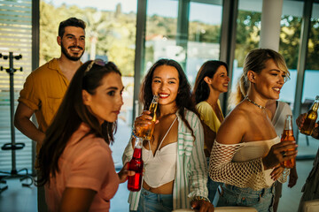 A group of friends engage in lively conversation, having food and drinks, sharing a joke, and...