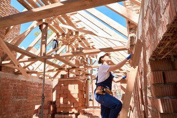 Confident woman building engineer climbing wooden ladder up