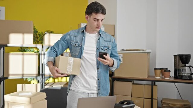 Young hispanic man ecommerce business worker using smartphone talking on telephone at office