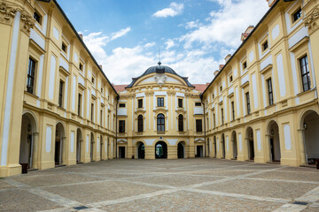 Fototapeta na wymiar Courtyard of the Slavkov (Austerlitz) castle with columns and windows and stone paving on the ground, Czech Republic.