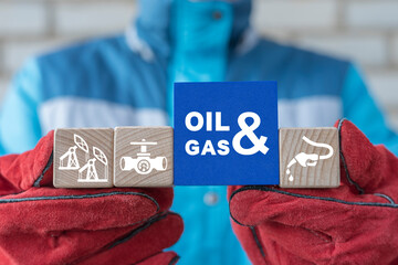 Engineer holding colorful blocks with icons and inscription: OIL AND GAS. Concept of oil and gas industry production manufacturing.
