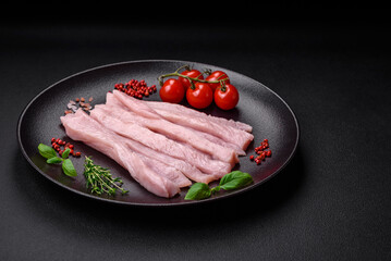 Raw chicken or turkey fillet cut into strips with spices and herbs