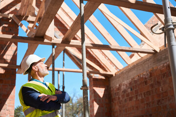 Male roofer contemplating about ceiling covering and attic design