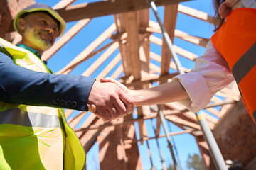 Obraz na płótnie Canvas Building developer shaking hand to contractor representative, making deal