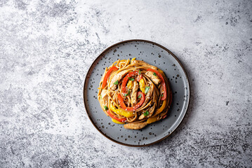 Buckwheat pasta with chicken, mango and red pepper in a plate