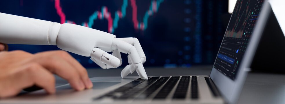 Automated stock trading concept. Robotic and human hand analyzing financial data on stock exchange, artificial intelligence utilization to predict precise price change in stock market. Trailblazing