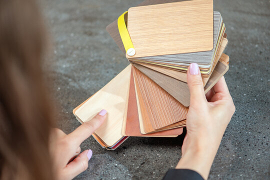 laminate samples. The choice of laminated surface for chipboard. Samples of wood imitation laminate in hands, close-up.
