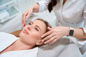 Obraz na płótnie Canvas Beautician makes a professional facial massage to the patient