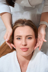 Fototapeta na wymiar Beautiful woman on face massage in cosmetology clinic