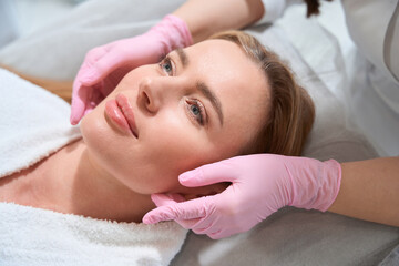 Fototapeta na wymiar Beautiful female on a facial massage in a cosmetology clinic