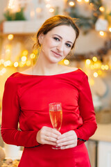 portrait of a woman in a red dress with champagne in a room with garlands.