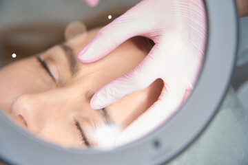 Doctor examines the interbrow folds of patient after beauty injections