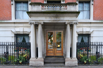 Apartment building's ornate portico entrance with ionic stone columns