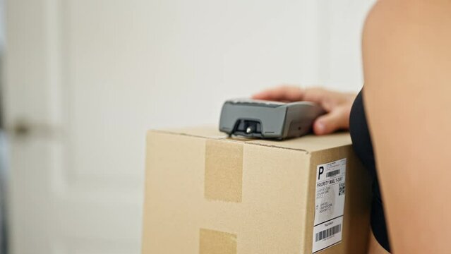 Middle age woman receiving package paying with credit card at home