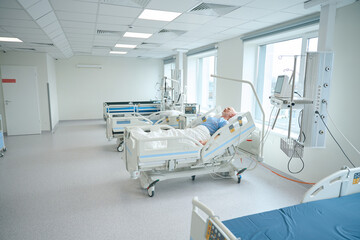 Patient on bed in resuscitation with hospital equipment